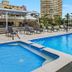 Sunbird Beach Resort Main Beach pool deck with loungers, shade umbrellas and high-rise buildings