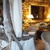 Son Mercadal in Porreres: rustic stone lounge with wicker chairs, table lamps and a curtained window