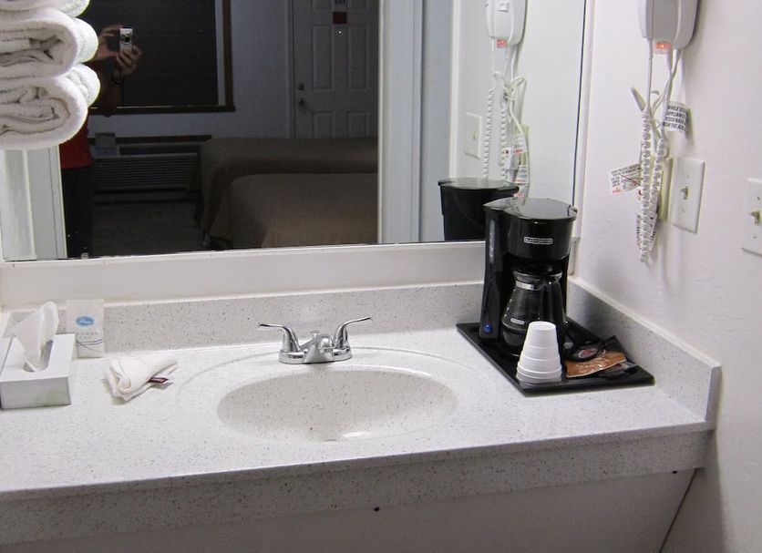 Cassville Budget Inn bathroom vanity with sink, mirror and coffee maker in Cassville