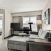 Residence Inn by Marriott Davenport suite with living area, sofa, desk, TV, and bedroom visible through doorway