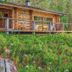 Basecamp Oulanka in Kuusamo, rustic cabin with wood deck overlooking lush forest hillside