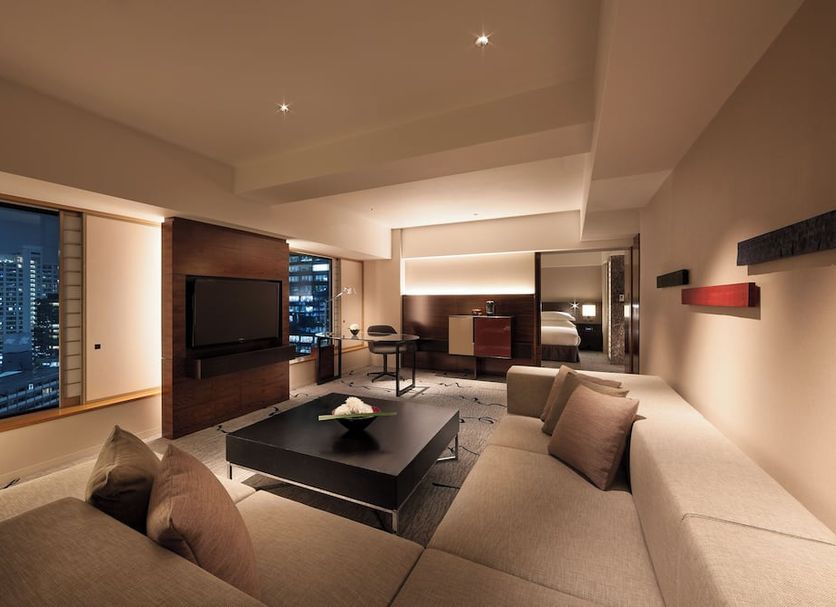 Hilton Tokyo in Tokyo guest suite with city skyline view, sectional sofa and TV