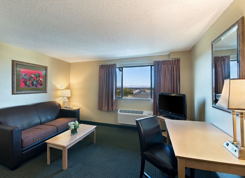 Oxnard Inn Lancaster room with sofa, desk, TV, window view and lamp in Lancaster