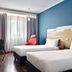 Holiday Inn Express Milan - Malpensa Airport guest room with twin beds, desk, chair and blue accent wall