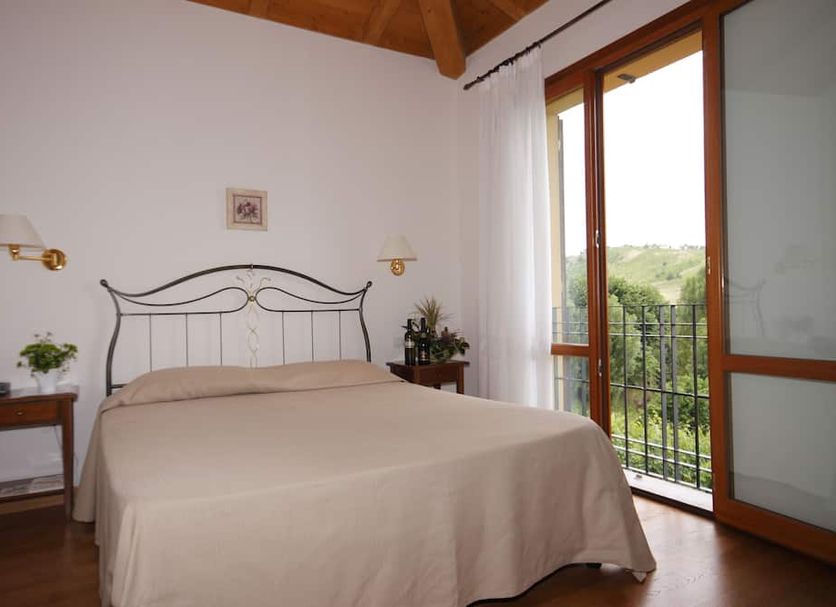 Agriturismo Borgo delle Vigne bedroom in Zola Predosa with balcony and countryside view