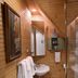 The Queen, A Victorian Bed & Breakfast bathroom with wood walls, sink, mirror, and glass shower in Bellefonte