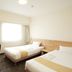 Smile Hotel Kumagaya guest room with two single beds, desk, chair, and window in Kumagaya