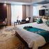 Great Wall Hotel (Yichang Cbd Food Street Store) guest room with king bed, TV and seating area