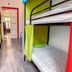Pal's Mini Hostel in Budapest dorm room with colorful bunk beds and narrow wood floor hallway