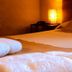 Hosteria La Raclette room with bed, folded towels, and warm bedside lamp in San Martín de los Andes