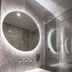 Boemio Flh Hotels Lisbon bathroom with round backlit mirror, white sink and glass shower enclosure