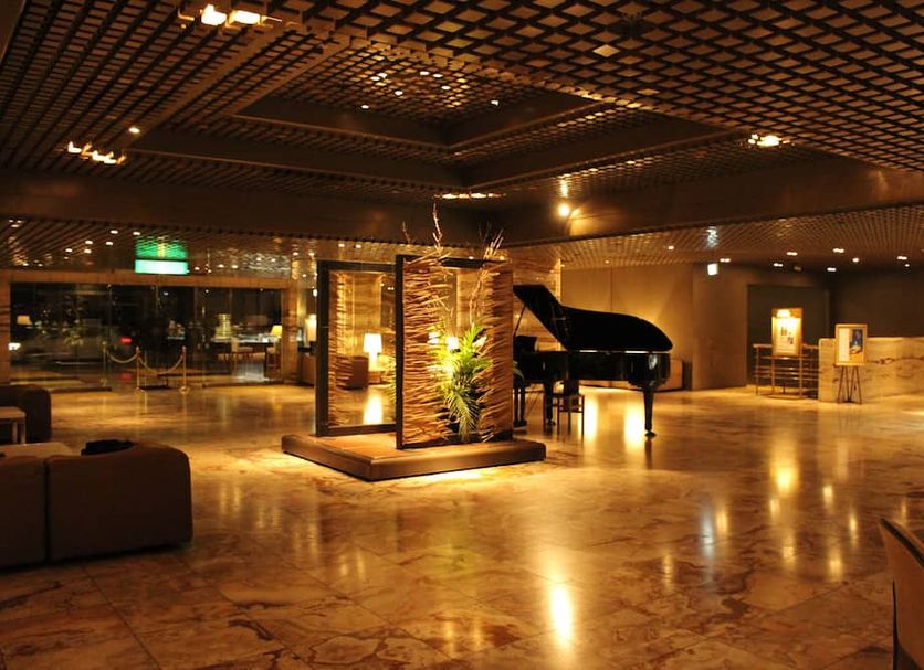 Gunma Royal Hotel in Maebashi lobby with grand piano, warm lighting, and polished marble floors