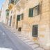 Carmelita Valletta exterior on a steep Valletta street, with stone facade and green shutters
