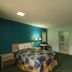 Travelodge by Wyndham Parkersburg guest room with bed, desk, TV and teal accent wall