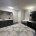 Studio 6 Huntsville room with kitchen, desk, TV, and bed in Huntsville