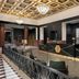 The Warrior Hotel, Autograph Collection lobby in Sioux City with black reception desk and patterned gold ceiling