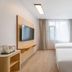 Hi Inn (Xuzhou Yunlong Wanda Plaza) guest room with two beds, wall-mounted TV, and window in Xuzhou