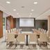 NH Madrid Nacional meeting room in Madrid with conference table, projector screen, and city-view windows