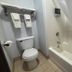 Jacksonville Inn & Suites bathroom with toilet, bathtub, shower curtain and towel rack in Jacksonville