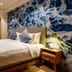 The Moana in Chatan guest room with double bed, woven chairs, balcony doors and ocean-inspired wall art