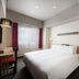 ibis Styles Kyoto Station room in Kyoto with a double bed, desk, wall-mounted TV, and large window