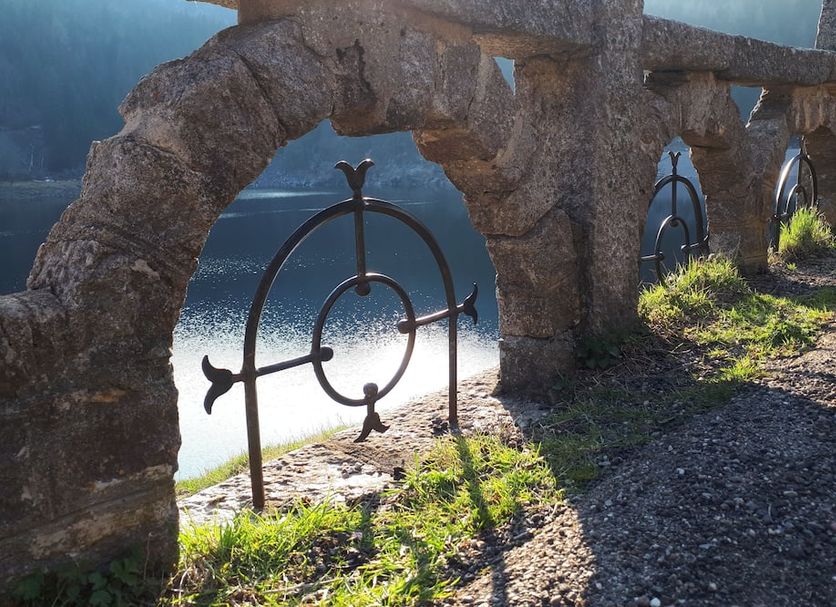 Hôtel Au Vieux Moulin in Le Bonhomme, stone archway overlooking a sunlit water feature