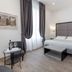 Apollo Guest House Florence guest room with double bed, chairs and tall curtained windows