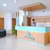 Hotel De Ecobiz Ahmedabad reception desk with wood paneling and a staff member behind the counter