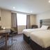 Premier Inn Edinburgh Airport - M9 Jct1 guest room with two beds, desk, chair and window in Edinburgh