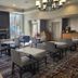 Philadelphia Suites at Airport lobby seating area with tables, chairs, fireplace, and large windows