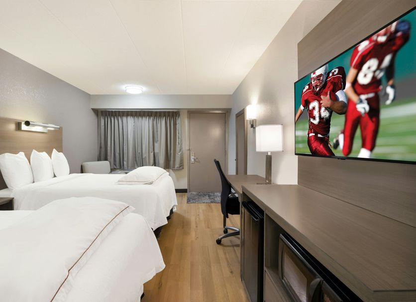 Red Roof Inn Plus+ Chicago - Naperville guest room with two beds, desk and wall-mounted TV