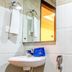 OYO 1594 Hotel Landmark bathroom with wall mirror, sink, towel rack and shower fixture in Visakhapatnam
