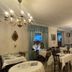 Hotel De La Paix Interlaken dining room with set tables, chandeliers, and large windows
