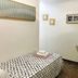 La Caleta de Tamariu room with single bed, small folding table and chairs, and wall art in Tamariu