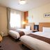 Comfort Hotel Tomakomai guest room with two beds, desk, TV and window in Tomakomai