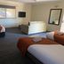 Armidale Pines Motel, Armidale: spacious guest room with three beds, wall-mounted TV and mirror