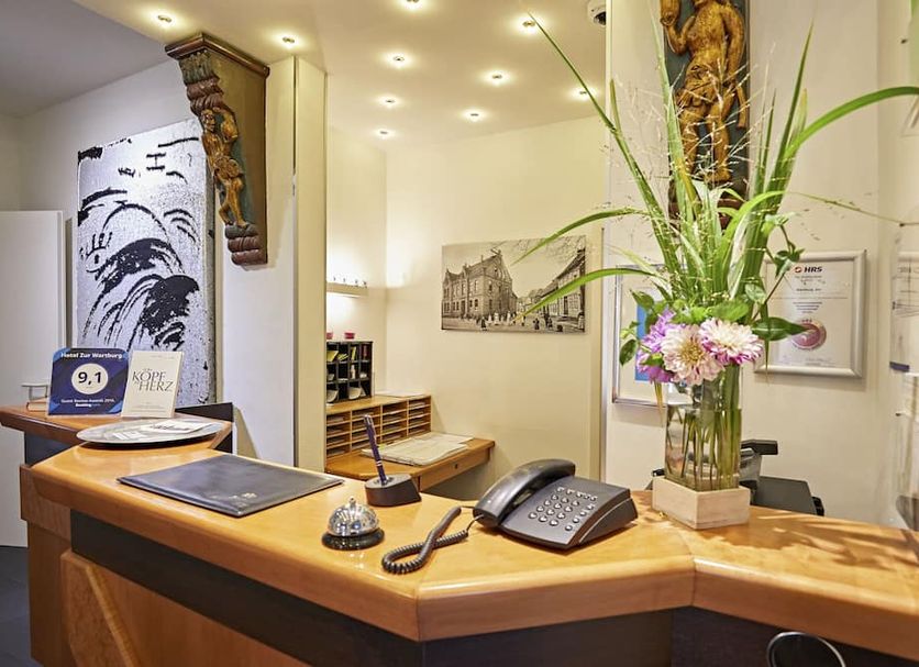 Hotel Zur Wartburg reception desk with flowers and seating in Rheda Wiedenbrueck