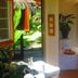 Sans Souci Inn, Pohara: bright bathroom with sink, potted plant and garden view through open door