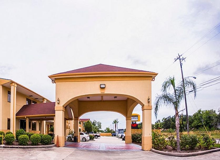Downtowner Inn and Suites in Houston with covered drive-through entrance and palm trees