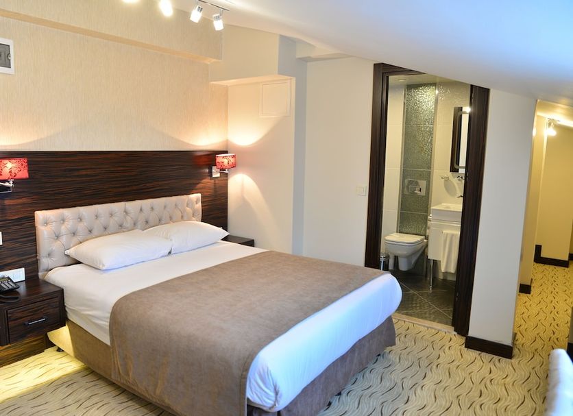 Golden Siyav Hotel in Istanbul guest room with double bed, bedside lamps and bathroom doorway