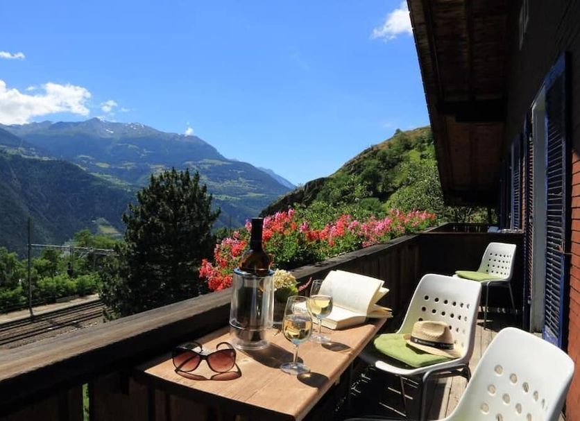 Long & Short Stay Hotel Bahnhof Ausserberg balcony with table, chairs and mountain valley view in Ausserberg