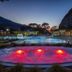 Grand Hotel des Bains in Lavey-Morcles with illuminated outdoor pool and hot tub at dusk