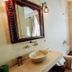 Riad Dar Ayur Marrakech bathroom with carved mirror, vessel sink, and freestanding bathtub by window