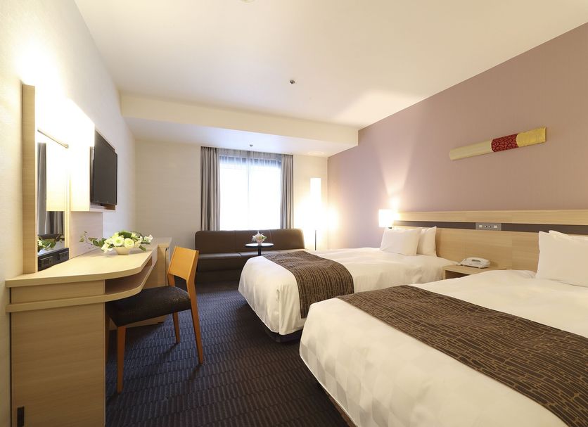Karasuma Kyoto Hotel room in Kyoto with two twin beds, desk, sofa and window light