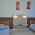 Hotel Blue Star II in Foz do Iguaçu: twin room with two single beds, wall art, and blue blinds