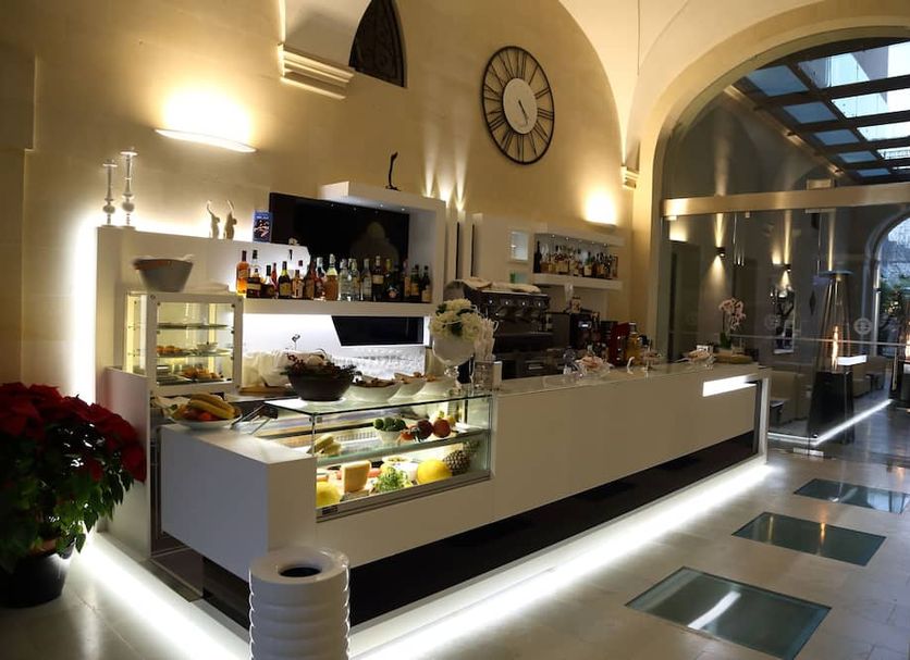 Hotel Belami Maglie lounge bar with illuminated counter, arched ceiling and glass-covered walkway