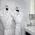 La Villa Haussmann, Paris: marble bathroom with two white bathrobes hanging beside a double vanity