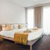 Appart'City Confort Lille Grand Palais bedroom with bed, window curtains and wall-mounted TV in Lille