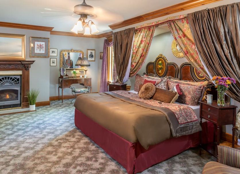 Angel at Rose Hall in Eureka Springs guest room with fireplace, king bed and draped canopy decor