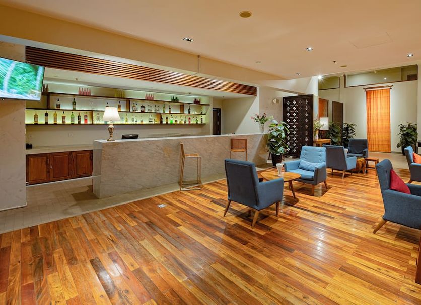 Hotel Somadevi Angkor Boutique and Resort lobby lounge with wooden floors and blue armchairs in Siem Reap